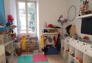 Colorful children’s playroom with toys, costumes, and a dollhouse