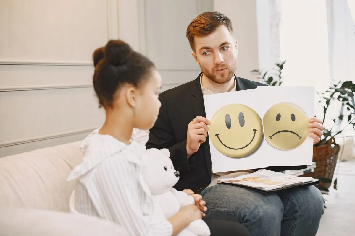 Therapist using emotion cards with a child in a CBPT session