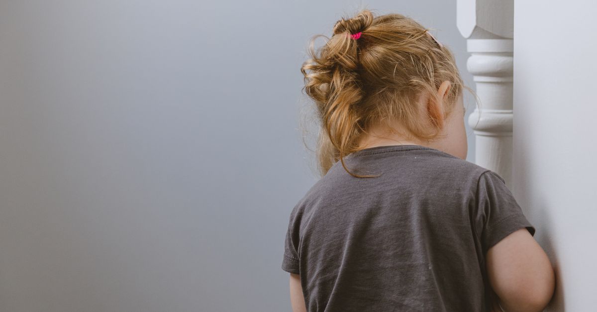 Frightened child shielding face, reacting to a feared trigger